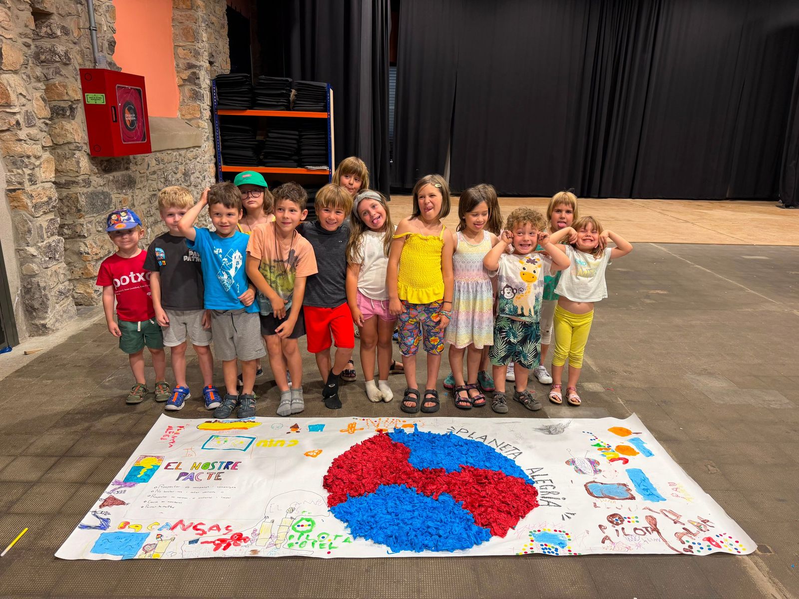 Infants del casal amb el mural Planeta Alegria