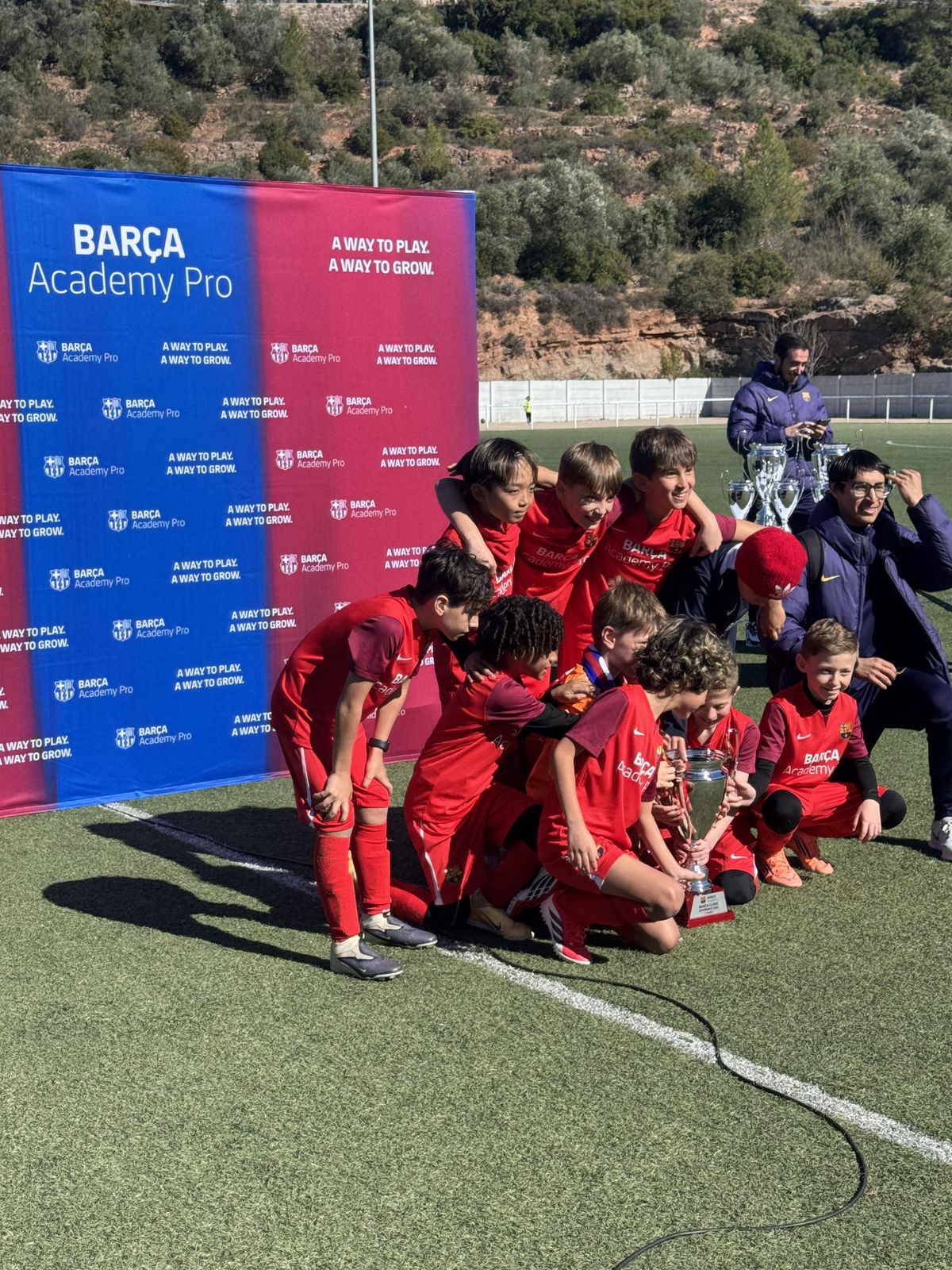 Equip infantil celebrant amb el trofeu al final d'un torneig de futbol