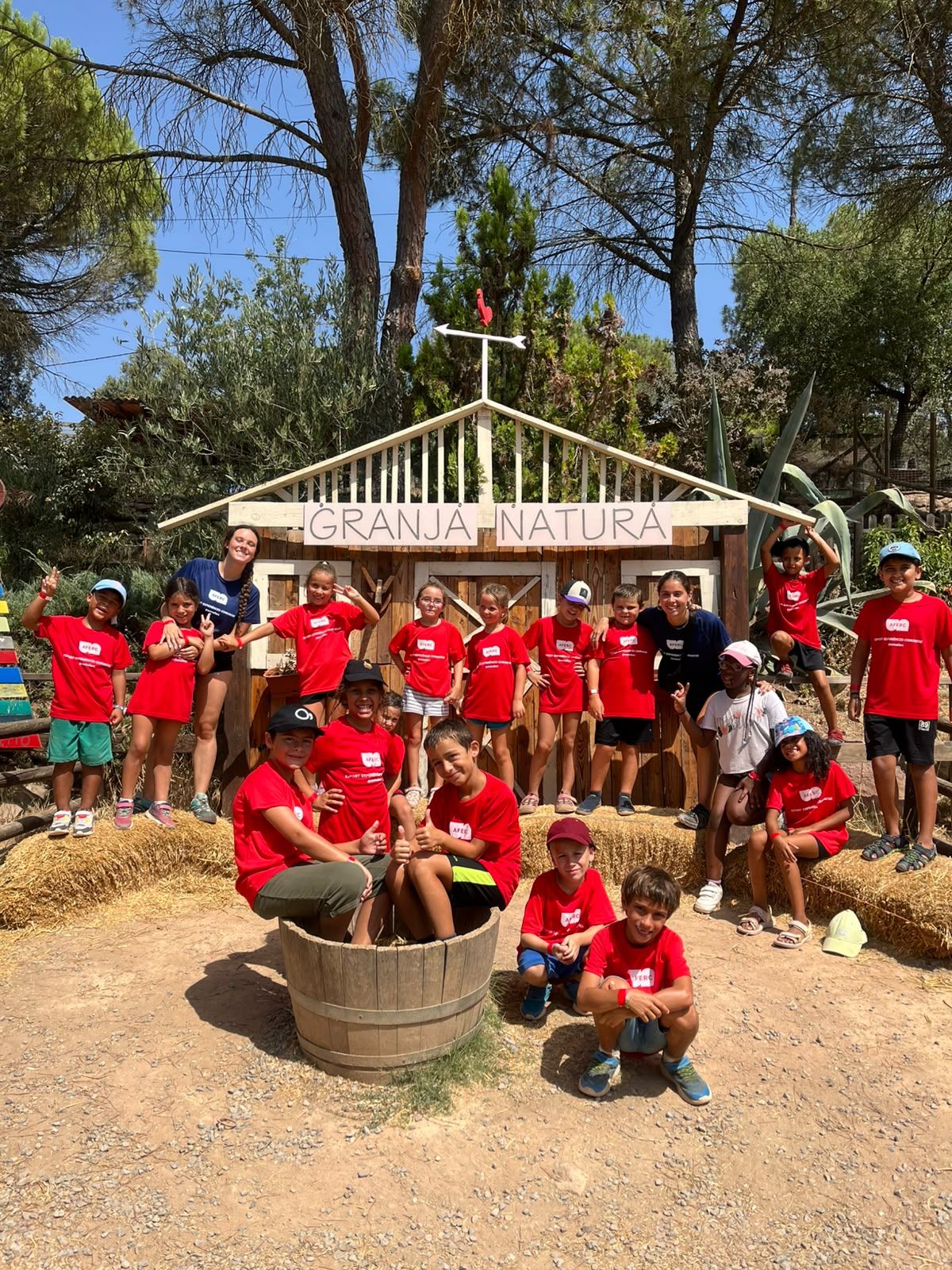 Grup d'infants i monitores amb la samarreta d'AFERC a la Granja Natura